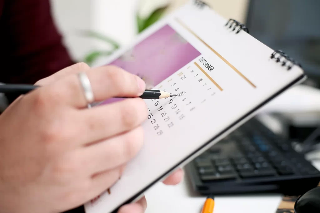 Een agenda met potlood en calculator, handig om afspraken en gewerkte uren als zzp’er overzichtelijk bij te houden.