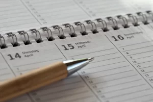 Beroemdheden Een overzichtelijke planning met pen en agenda, ideaal voor het bijhouden van gewerkte uren en afspraken als zzp’er.